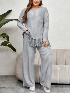 Detail of light grey knit set featuring irregular fringe hem and ribbed texture fabric