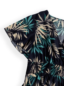 Detail of V-neck summer dress with tropical leaf print and elastic smocked waistline