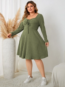 Detail view of olive green ribbed dress featuring square neckline and bow tie design