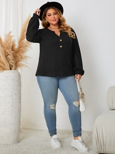 Detail of plus size black long sleeve top featuring lace hollow sleeves and button accents