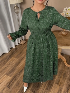 Detail of green polka dot dress featuring adjustable drawstring neckline and elastic waist