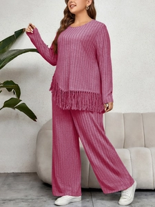 Close-up of rose pink ribbed knit set showing tasseled hem and soft textured fabric
