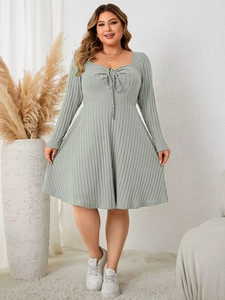Detail of light green ribbed knit dress with square neck and decorative drawstring