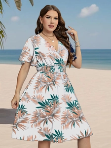 Detail of V-neck summer dress with tropical palm leaf print and smocked waist design