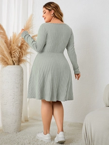 Detailed texture of sage green ribbed knit fabric on a plus size long sleeve dress