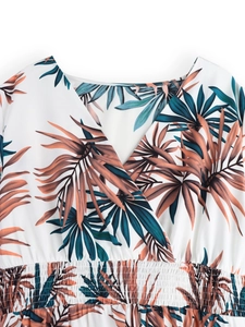 Detail of cross V-neck and smocked waist on tropical palm leaf print summer dress