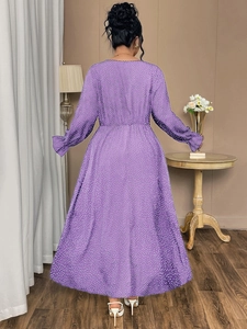 Detail of purple polka dot plus size dress showing the flowing A-line back and ruffles