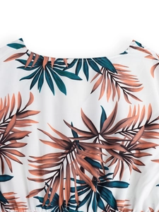 Detail of V-neckline and tropical palm leaf print on white lightweight summer fabric