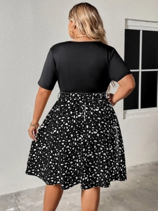 Detail view of the back of a plus size V-neck dress with polka dot print skirt