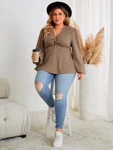 Detail view of the deep V-neck and stylish twist-front knot on this brown plus size top