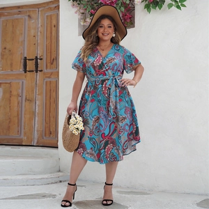 Blue paisley print dress with V-neckline and ruffled sleeves in a summer resort setting