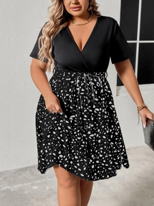 Detail view of the V-neck short sleeve dress with waist tie and floral print skirt