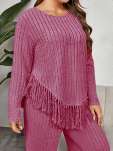 Detail view of pink knit lounge set featuring vertical ribbed texture and long fringe hem