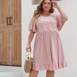 Détail d'une robe bohème rose grande taille avec dentelle florale et longs glands à franges