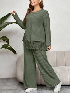Detail of green ribbed knit set with asymmetrical hem and long fringe tassels