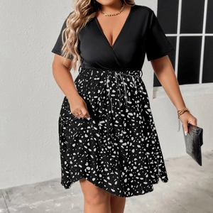 Detail of V-neck short sleeve dress with adjustable waist tie and polka dot print pattern