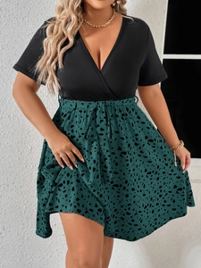 Detail showing the crossover V-neck design and stylish polka dot print belt of the dress