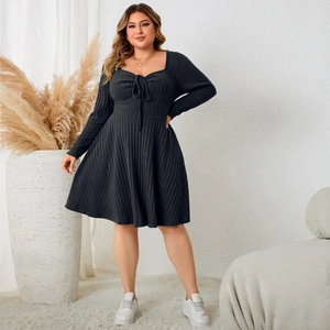 Detail of plus size black ribbed dress featuring a heart neckline and bow tie design