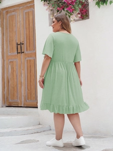 Détail d'une robe bohème grande taille vert clair avec ourlet à volants en extérieur