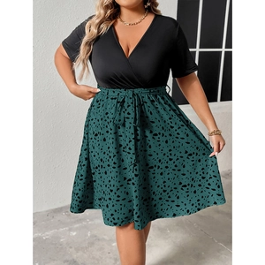 Plus size wrap dress with deep V-neck, short sleeves, and green polka dot skirt