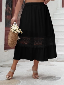 Detail of high-waisted black midi skirt featuring intricate lace hollow-out embroidery