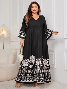 Detailed close-up of V-neck and white floral print on a long black bell sleeve dress