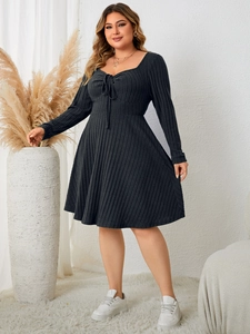Detail of dark grey ribbed knit dress with sweetheart neckline and tie-up front design