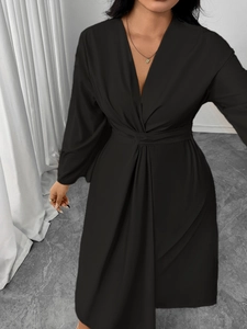 Detail of elegant black V-neck long sleeve dress with waist knot and satin finish