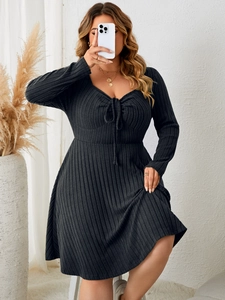 Detail of square neck knit dress featuring drawstring bow and ribbed texture