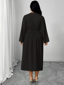 Back view of a long-sleeved black midi dress showing elastic high-waist pleated details