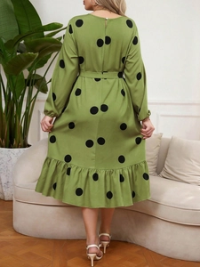 Rear view of green long sleeve polka dot dress with waist tie and ruffled hem details