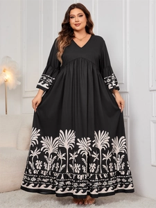 Detail of flared sleeves with tropical palm and wave prints on a black maxi dress