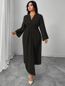 Detailed close-up of the waist knot and pleated design on this black long-sleeve dress
