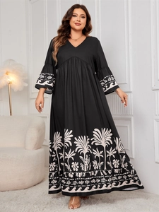 Detail of V-neck printed long dress with flared sleeves and palm tree pattern