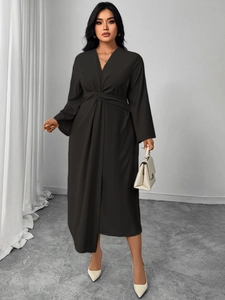 Detailed view of elegant black V-neck dress featuring unique waist twist knot and pleated design