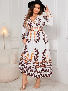 Detail of V-neck printed bohemian maxi dress with orange botanical patterns and ruffled hem