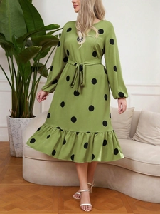 Detail of green polka dot dress showing the long sleeves and ruffled hem design