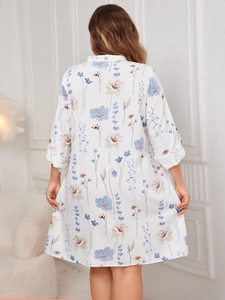 Back view of a white floral mid-length dress featuring a loose H-cut and soft cotton fabric