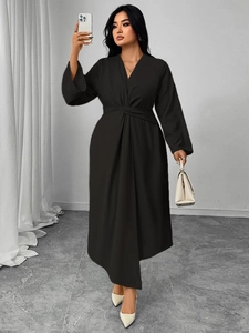 Detail of waist knot and pleated ruching on a slim-fit long-sleeve black V-neck dress