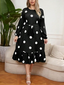 Detail of plus size black polka dot dress with long sleeves and waist tie belt