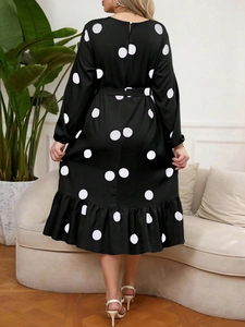 Back view of long-sleeved polka dot dress featuring a waist tie and ruffled hemline