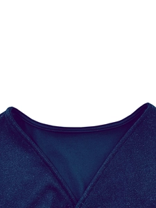 Detail of V-neckline and shimmering navy blue fabric with fine glitter on the evening gown