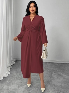 Detail of V-neck burgundy long sleeve dress with waist twist and elegant draping effect