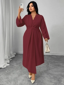 Detail of the waist twist design and asymmetrical hem on this burgundy V-neck dress