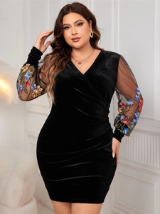Detail of elegant black velvet V-neck dress with floral embroidery on mesh sleeves