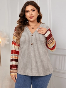 Detail of plus-size V-neck ribbed knit top featuring striped patchwork sleeves and buttons