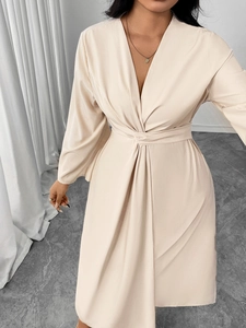 Detail of elegant beige deep V-neck dress with sophisticated waist twist knot design