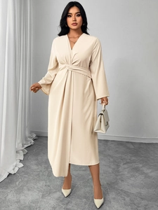 Detailed view of the V-neck and twist-knot waist on this elegant cream long sleeve dress