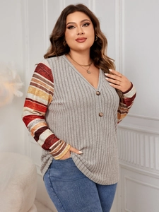 Detailed close-up of V-neckline with buttons and colorful striped sleeves on grey top