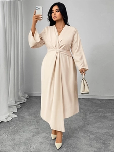 Detail of elegant beige V-neck long sleeve dress with waist twist and draped pleats